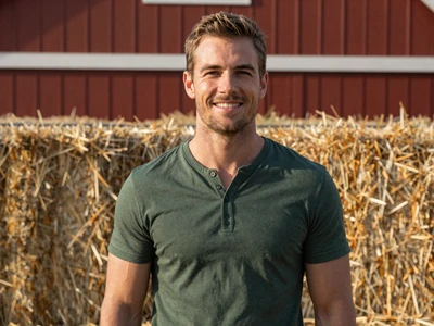 Ethan, a 32-year-old Christian grain farmer from Indiana smiling near a red barn