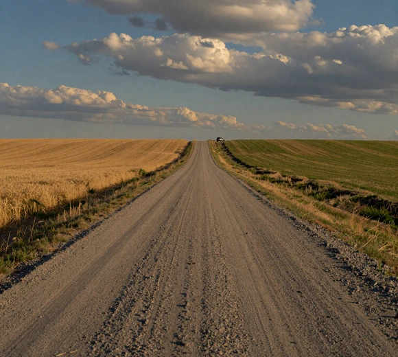 Long straight gravel road across Nebraska prairie with vast open sky - rural dating challenges in the Cornhusker State